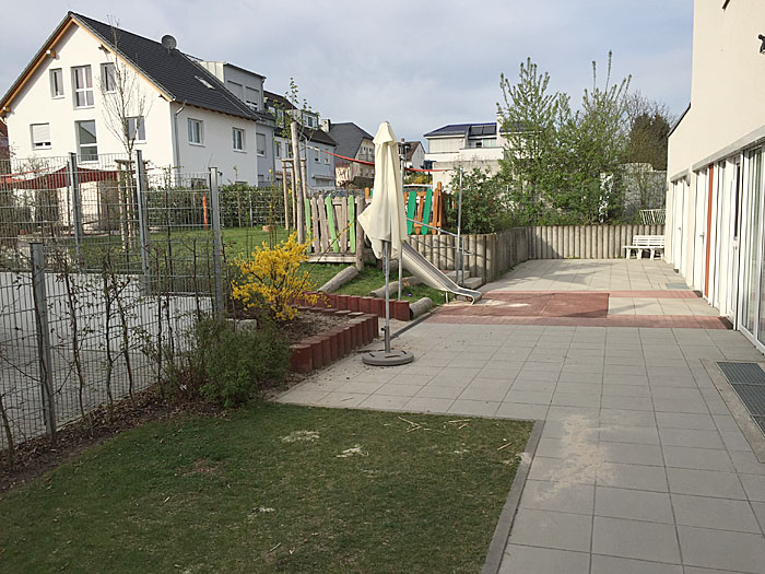 An der Seite gibt es den Garten mit Spielplatz.